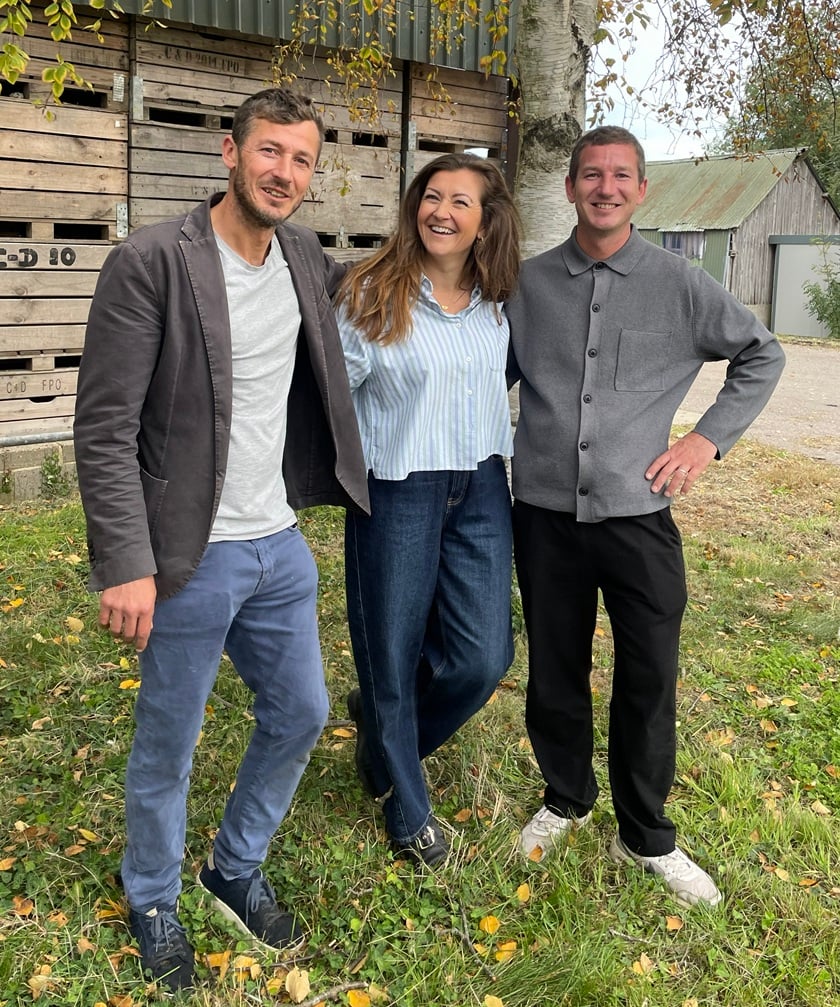 Sam houston, Hannah Isichei and Jack Houston standing on a fruit farm in Kent in front of a tree